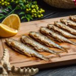 fried fishes set on wooden board